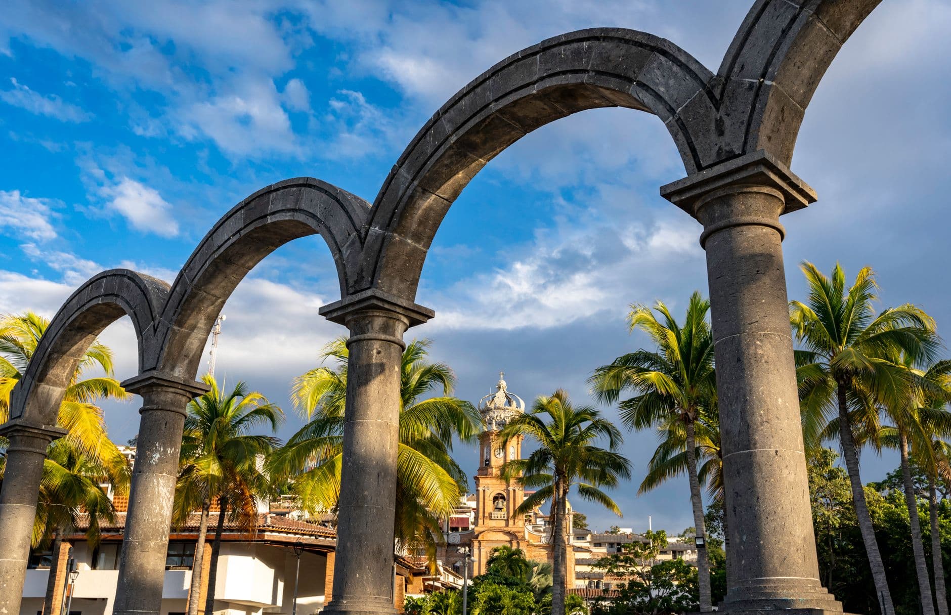 Los Arcos and palm trees along the Puerto Vallarta Malecon at dusk