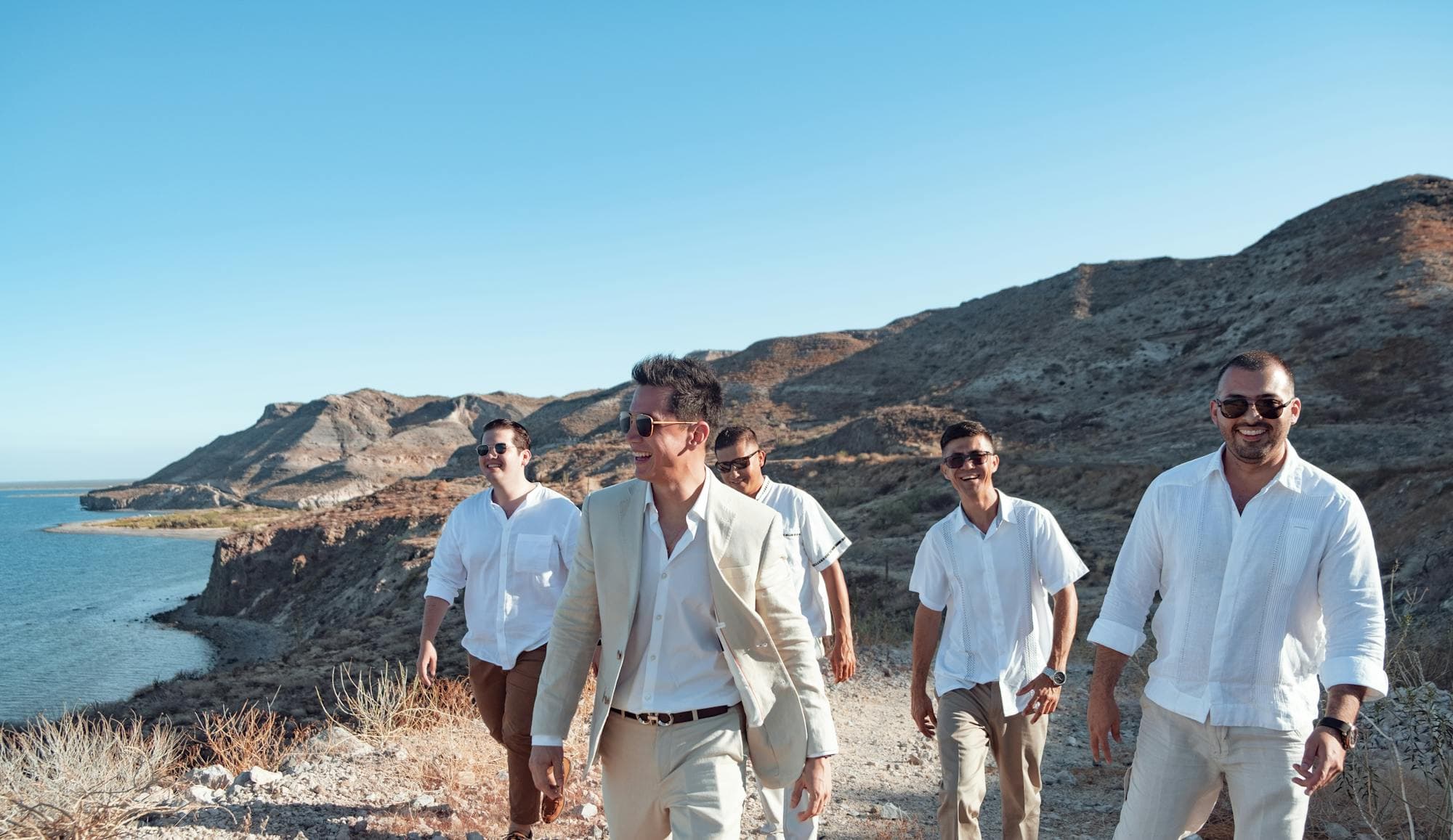 Friends walking together along a sunlit coastal cliff